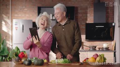 老年夫妇边看平板<strong>电脑</strong>边做饭